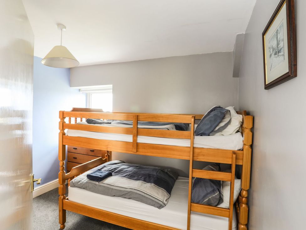 A bedroom with a bunk bed and a window at Bodlasan Groes House in Holyhead