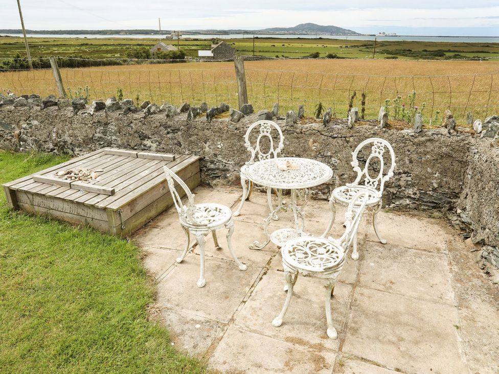 A garden with a table and chairs at Bodlasan Groes House in Holyhead