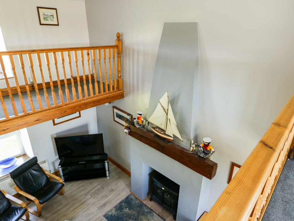 A living room with a fireplace and television at Bodlasan Groes House, Llanfachraeth