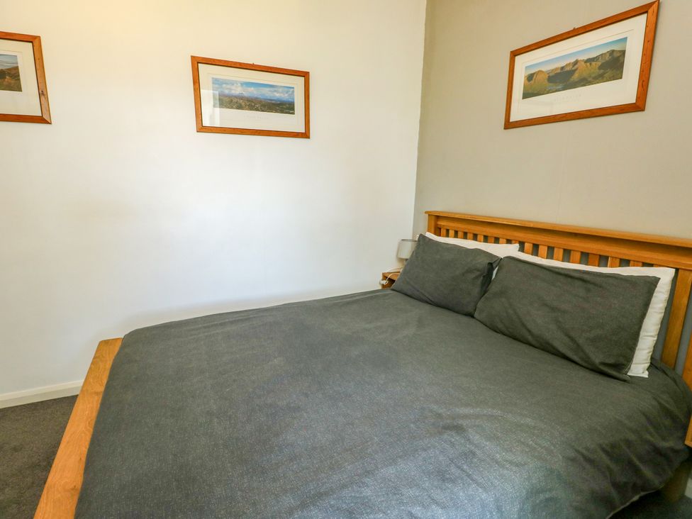 A bedroom with a bed and framed pictures at Bodlasan Groes House Llanfachraeth
