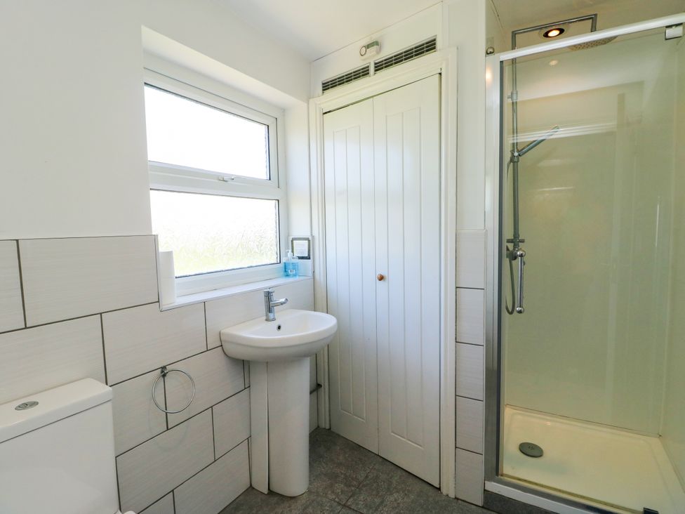 A bathroom with a shower, sink, and toilet at Bodlasan Groes House in Llanfachraeth
