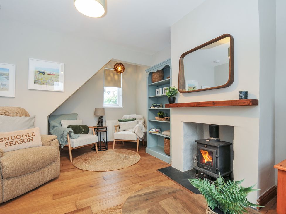 A living room with an armchair and a fireplace at 4 Polgrain Turning, St. Wenn near St Columb Major
