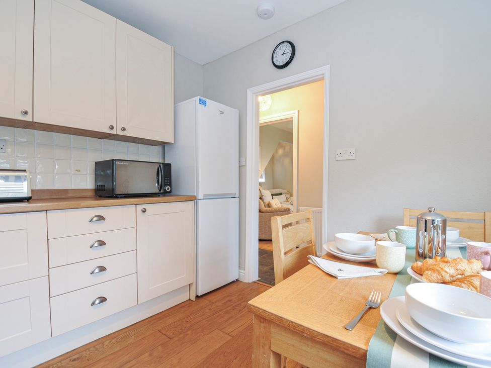 A kitchen with appliances and a dining table at 4 Polgrain Turning St. Wenn near St Columb Major