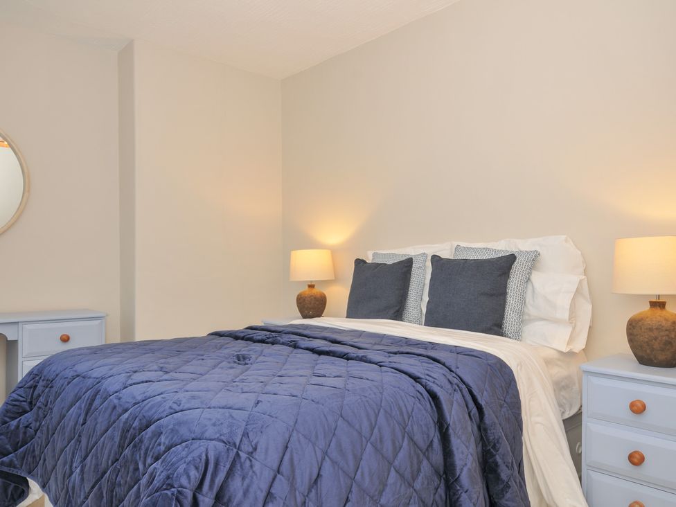 A bedroom with a bed and nightstands at 4 Polgrain Turning St. Wenn near St Columb Major