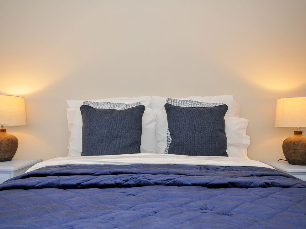A bed with pillows and lamps at 4 Polgrain Turning St. Wenn near St Columb Major