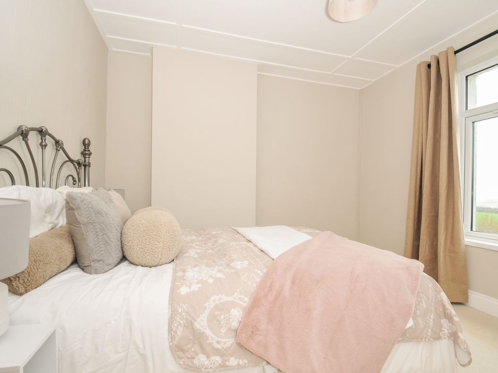 A bedroom with a bed and pillows at 4 Polgrain Turning St. Wenn near St Columb Major