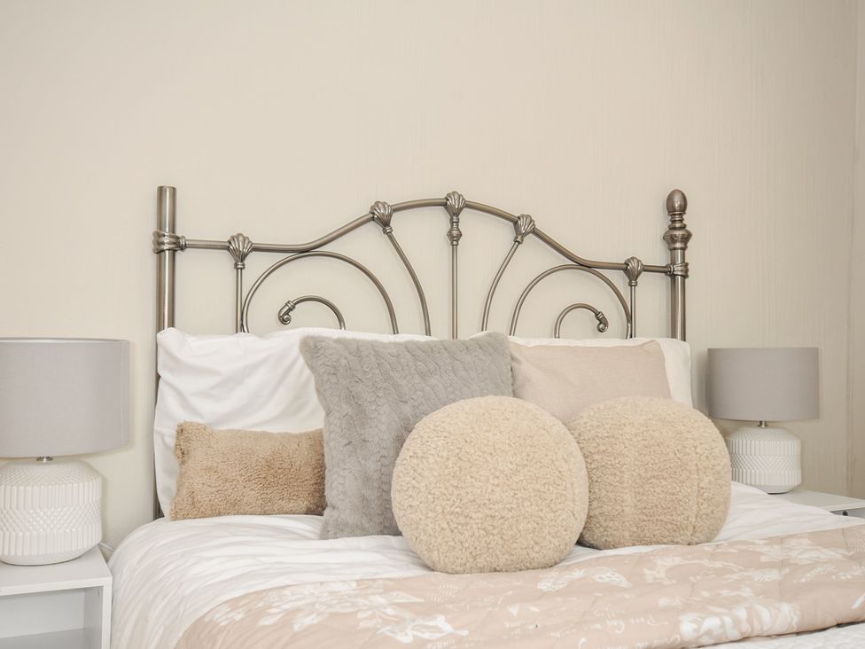 A bed with decorative pillows and bedside lamps at 4 Polgrain Turning St. Wenn near St Columb Major