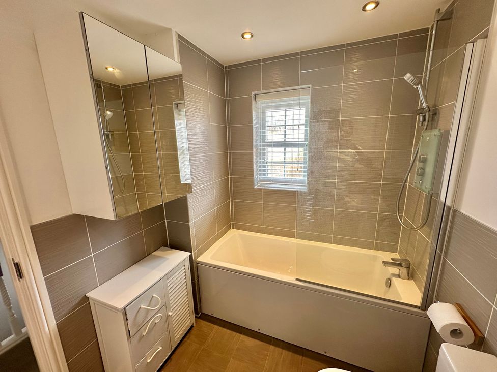A bathroom with a bathtub and shower at 2 Clarke Close in Cottenham