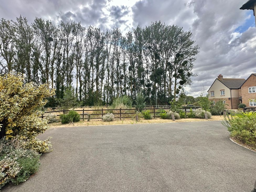 An outdoor view with trees and a house at 2 Clarke Close Cottenham