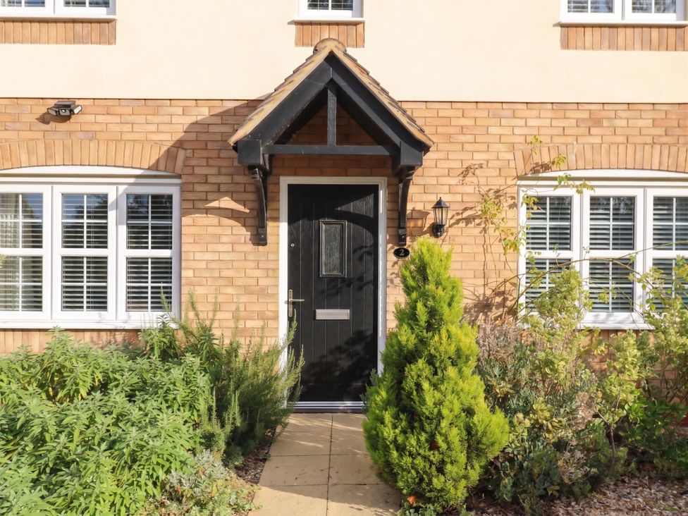 A front entrance with a black door and windows at 2 Clarke Close in Cottenham