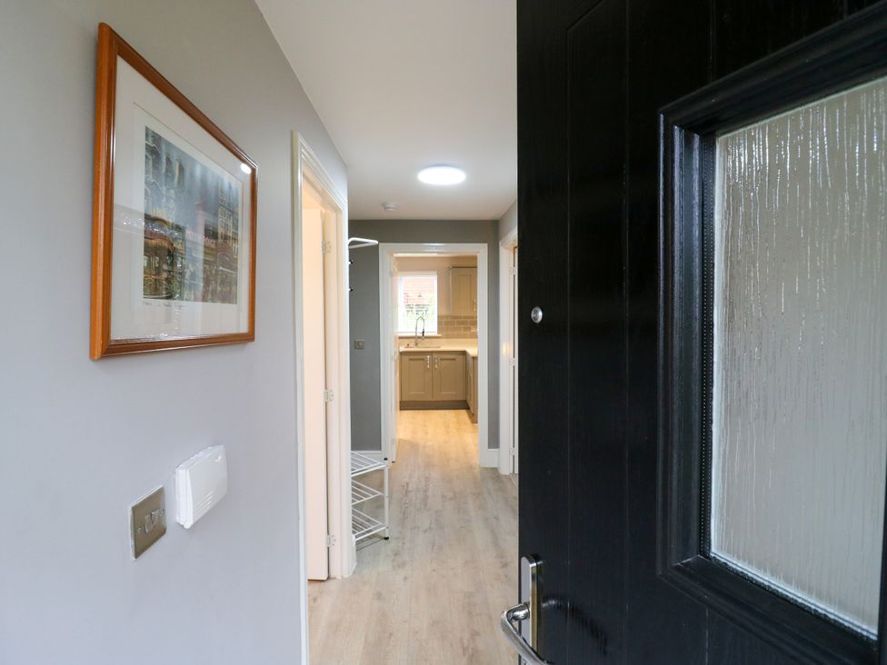 A hallway showing a door and a view into the kitchen at 2 Clarke Close in Cottenham