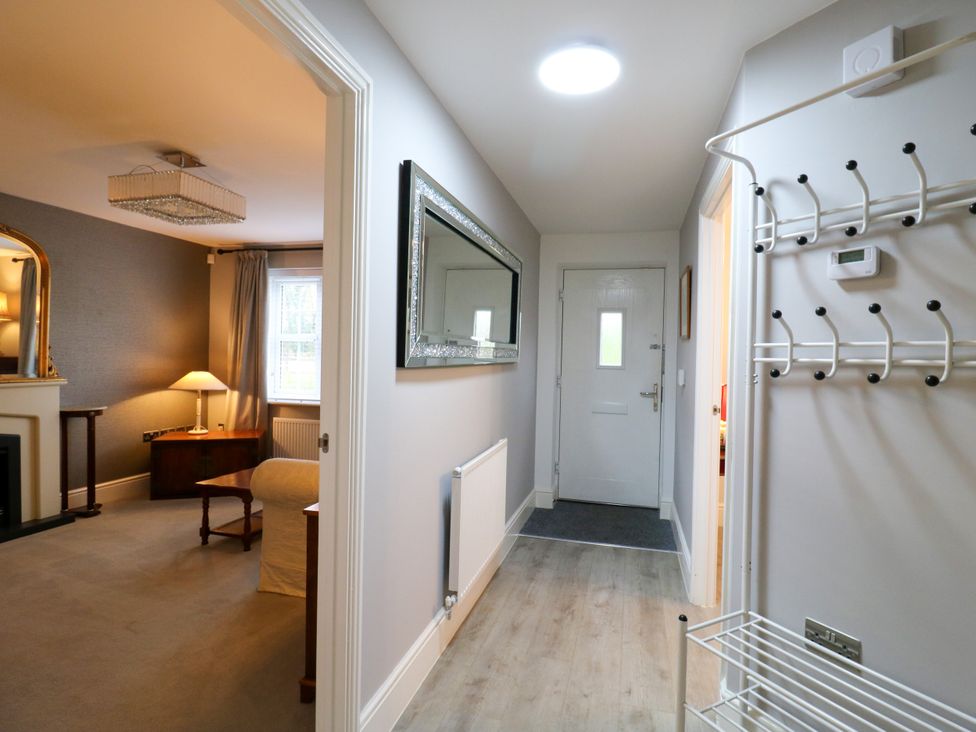 A hallway with a door and hooks at 2 Clarke Close in Cottenham