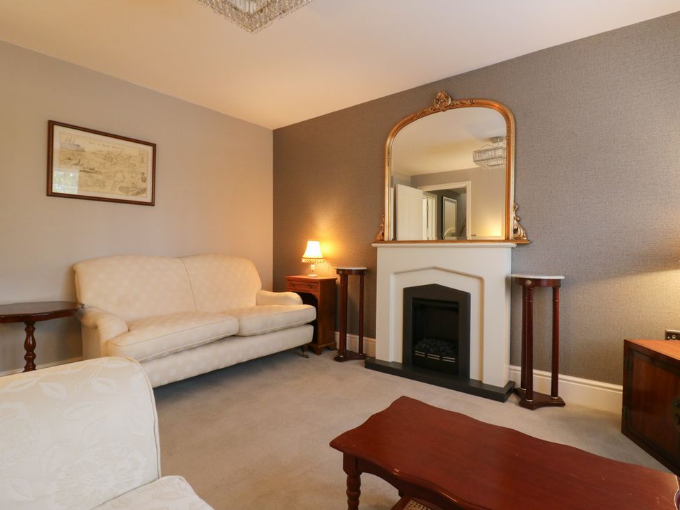 A living room with sofa and mirror at 2 Clarke Close in Cottenham
