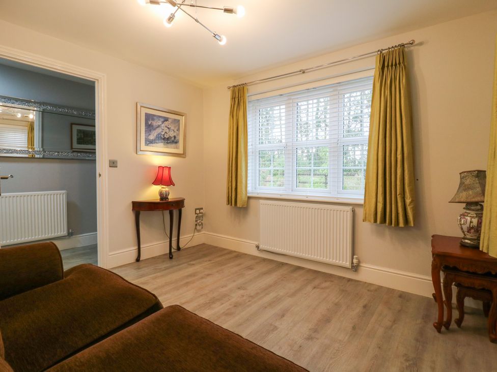 A sitting room with a sofa and lamp at 2 Clarke Close in Cottenham