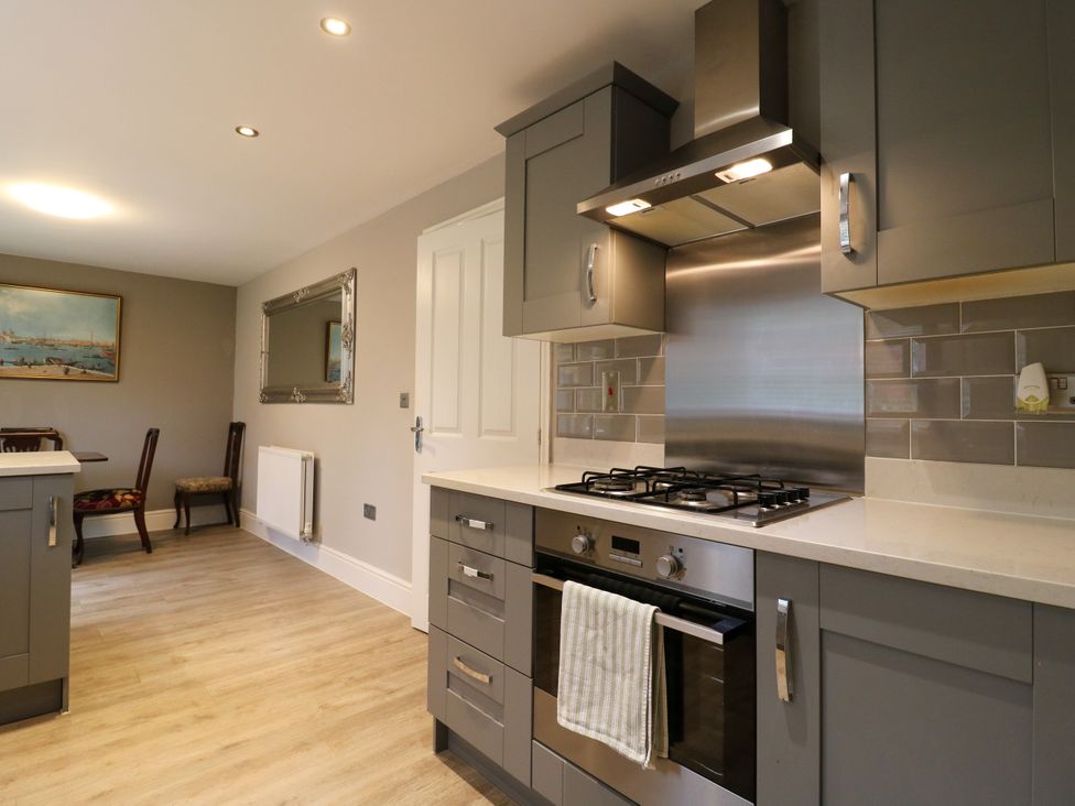 A kitchen with cabinets, stove, and seating at 2 Clarke Close in Cottenham
