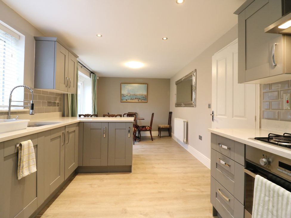 A kitchen with cabinets and a dining area at 2 Clarke Close in Cottenham