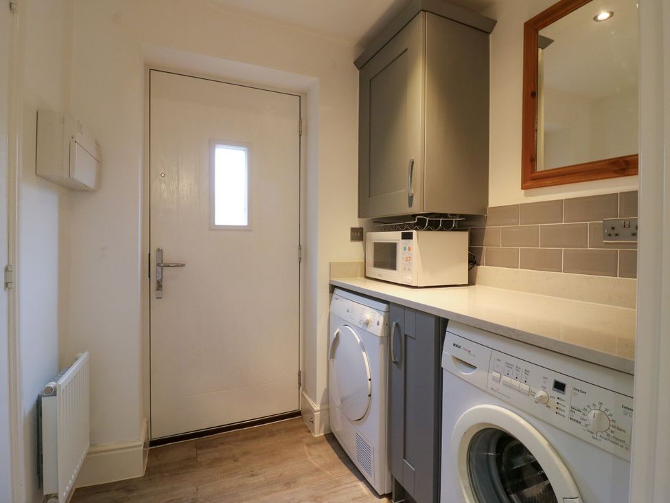 A laundry room with a washing machine and tumble dryer at 2 Clarke Close in Cottenham