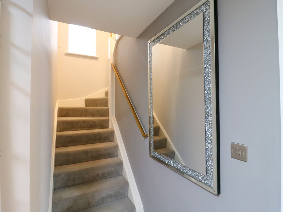 A staircase with a mirror and handrail at 2 Clarke Close Cottenham