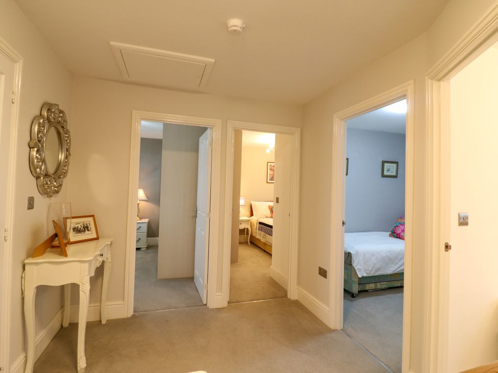 A hallway with doors to bedrooms and a table at 2 Clarke Close in Cottenham