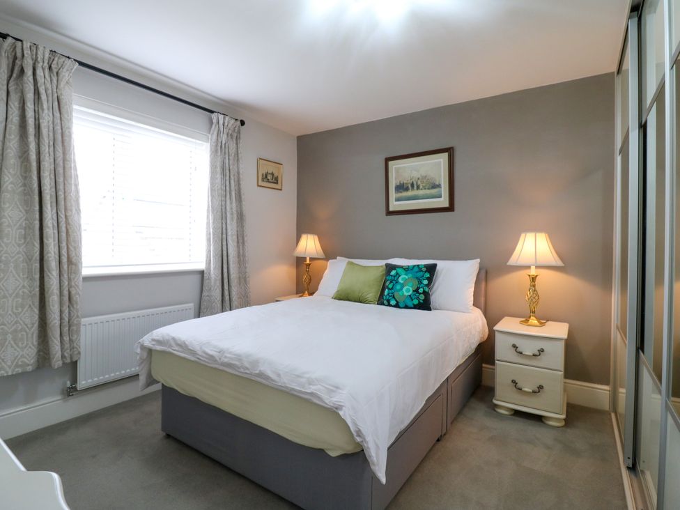 A bedroom with a bed, bedside tables and lamps at 2 Clarke Close Cottenham