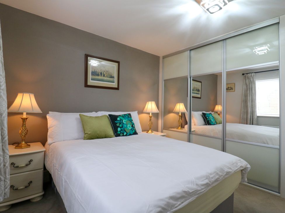 A bedroom with a bed and nightstand at 2 Clarke Close Cottenham
