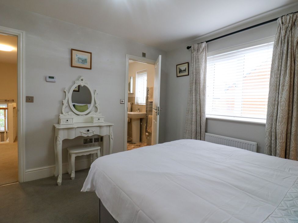 A bedroom with a bed and a dressing table at 2 Clarke Close in Cottenham