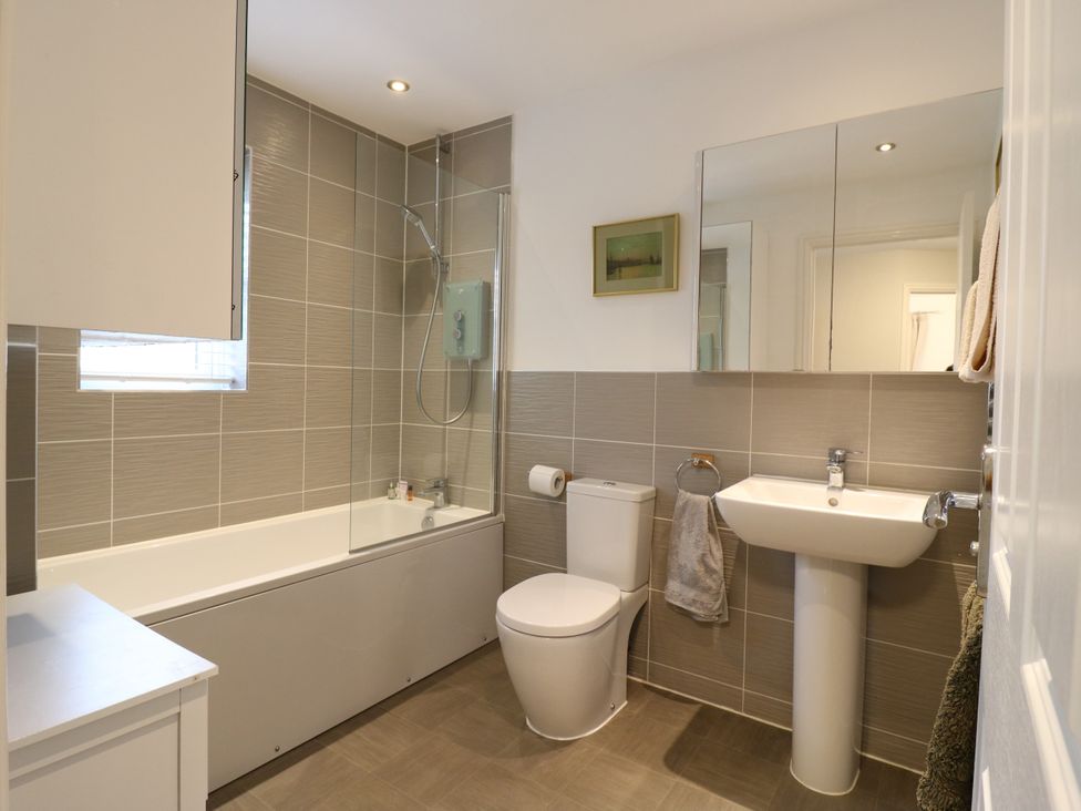 A bathroom with a bathtub, shower, toilet, and sink at 2 Clarke Close Cottenham