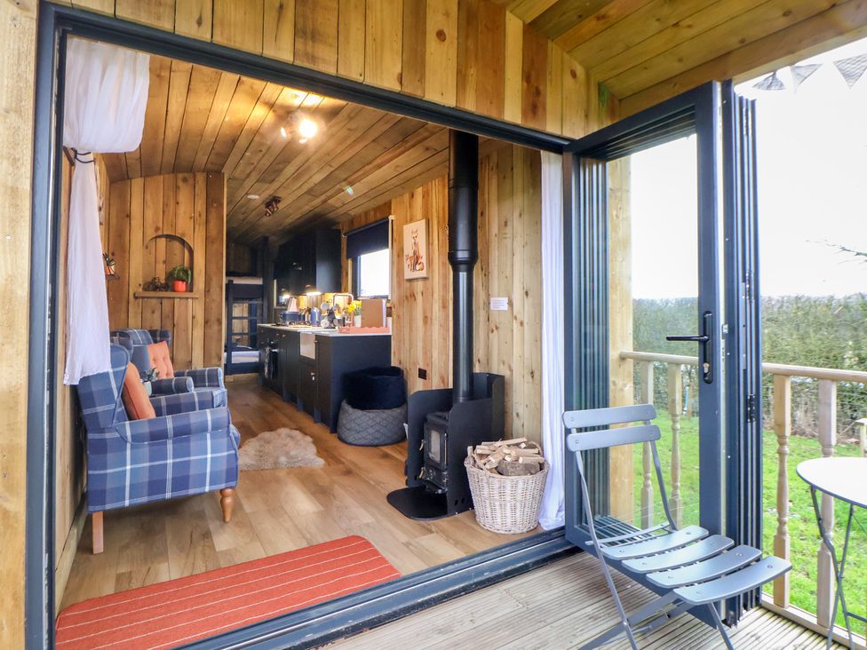 A living room with a sofa and stove at The Suffolk in Knutsford