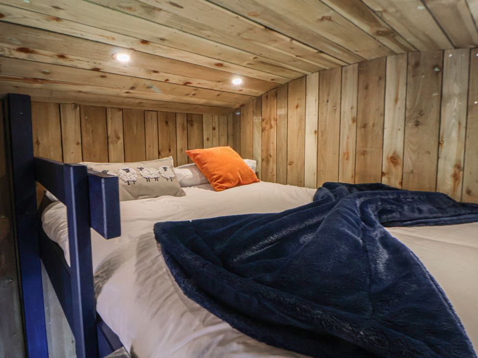 A bedroom with a bed and wooden paneling at The Suffolk in Knutsford
