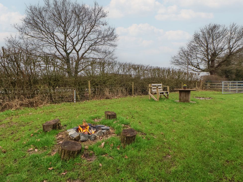 An outdoor area with a fire pit and seating at The Suffolk in Knutsford