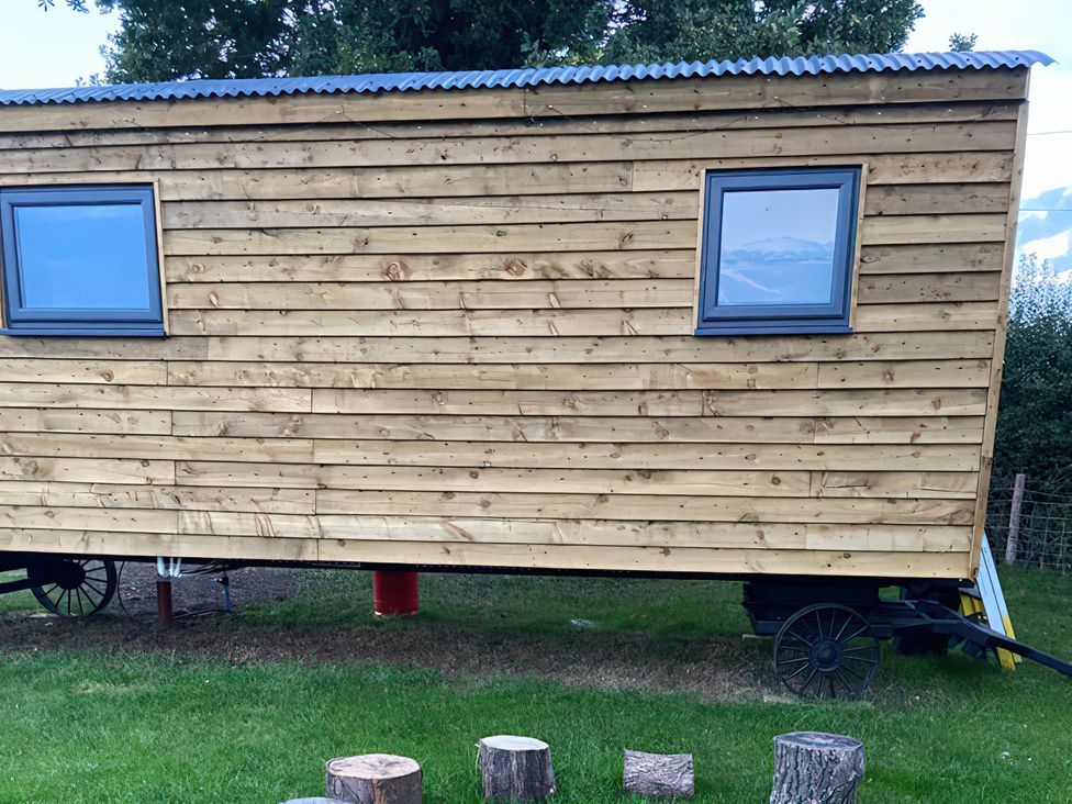 A wooden structure with windows on the side at The Suffolk Hut in Lower Peover, Cheshire