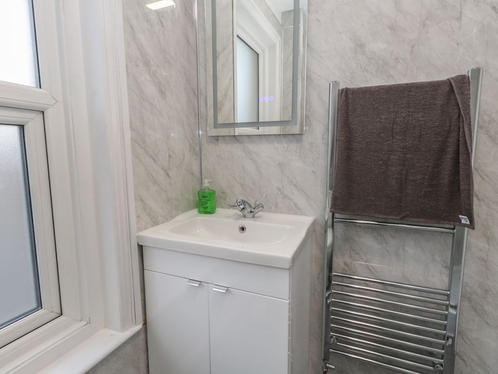 A bathroom with a sink and towel rack at 93 Abbotsbury Road Weymouth