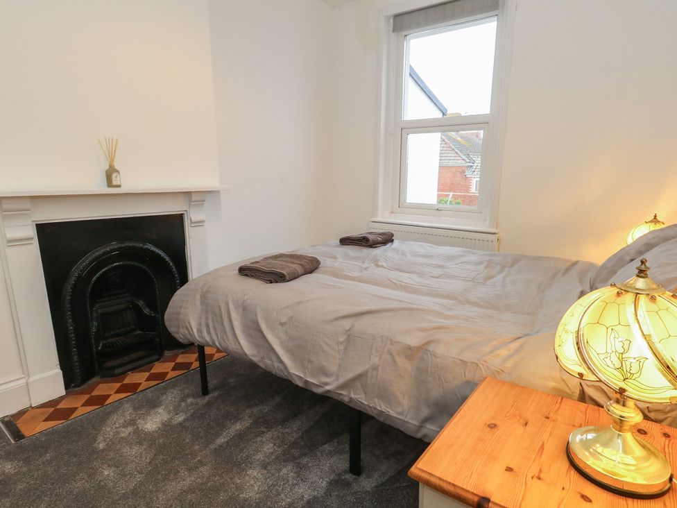 A bedroom with a bed and lamp at 93 Abbotsbury Road, Weymouth