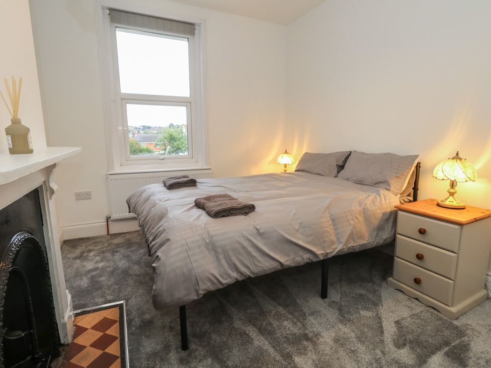 A bedroom with a bed, bedside lamps and a window at 93 Abbotsbury Road Weymouth
