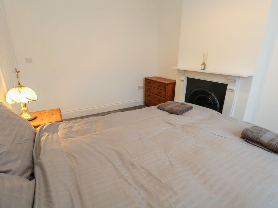 A bedroom with a bed and lamp at 93 Abbotsbury Road in Weymouth