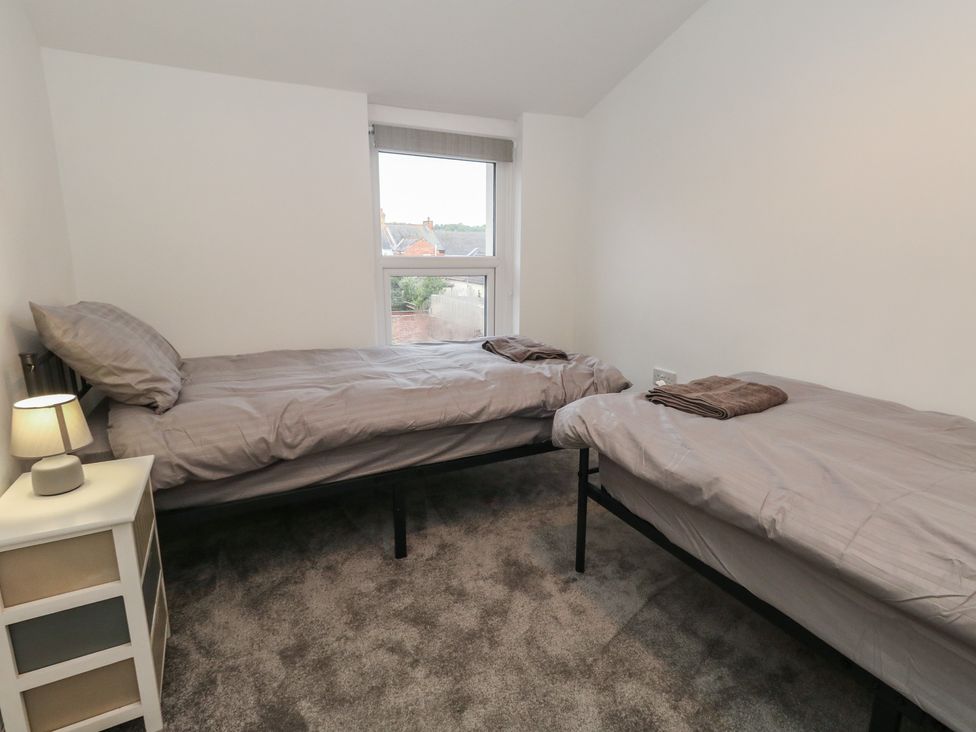 A bedroom with two beds and a lamp at 93 Abbotsbury Road in Weymouth