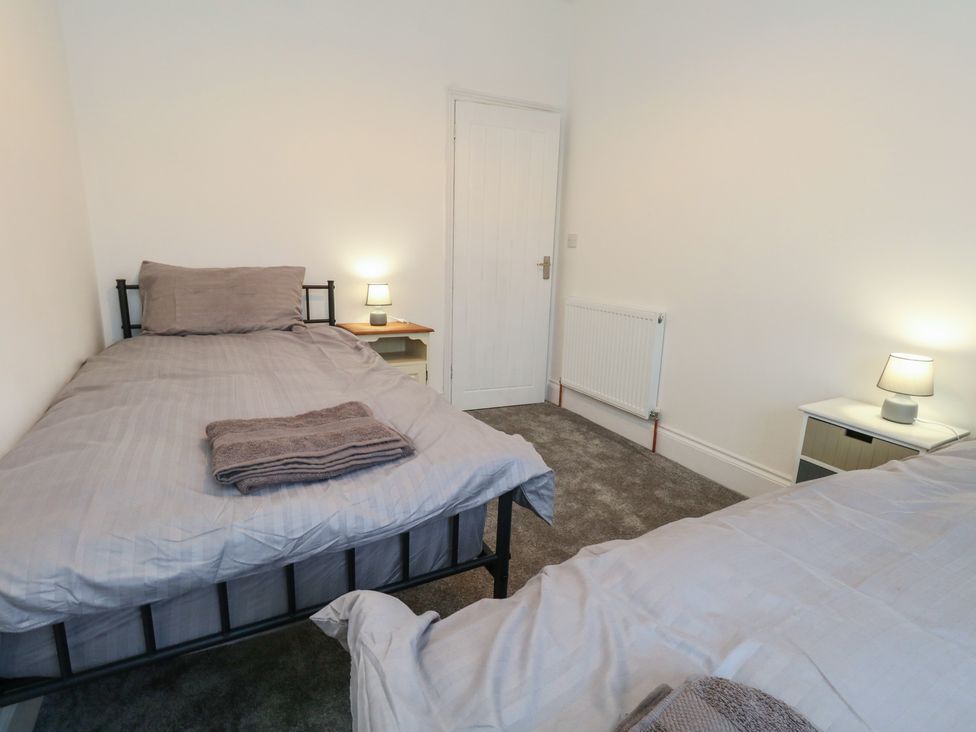 A bedroom with two single beds and a nightstand at 93 Abbotsbury Road in Weymouth