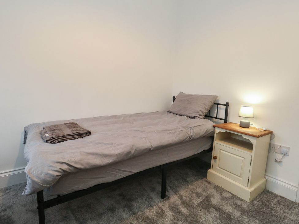 A bedroom with a bed and bedside table at 93 Abbotsbury Road in Weymouth