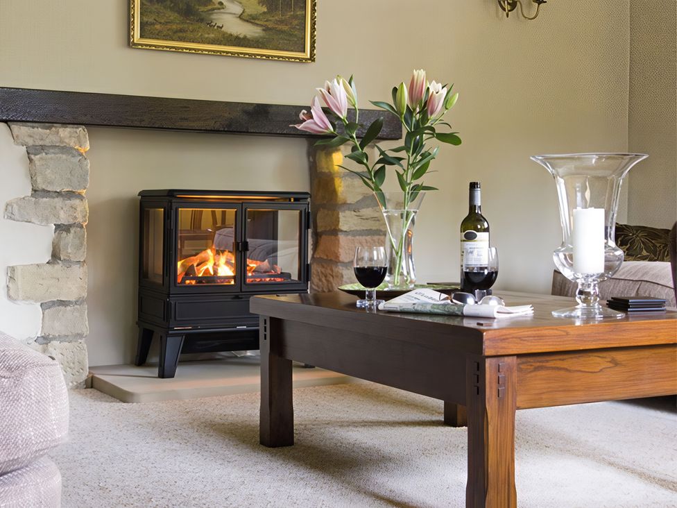 A living room with a fireplace and coffee table at Town Head Farm in Skipton