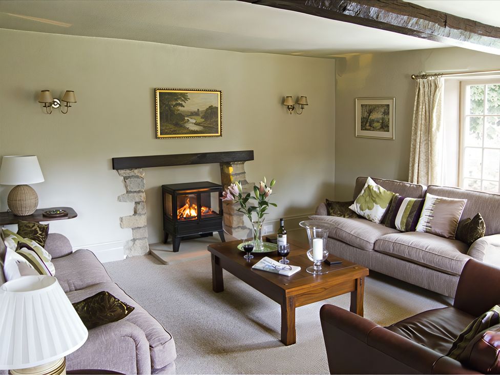 A living room with a fireplace and sofa at Town Head Farm in Skipton