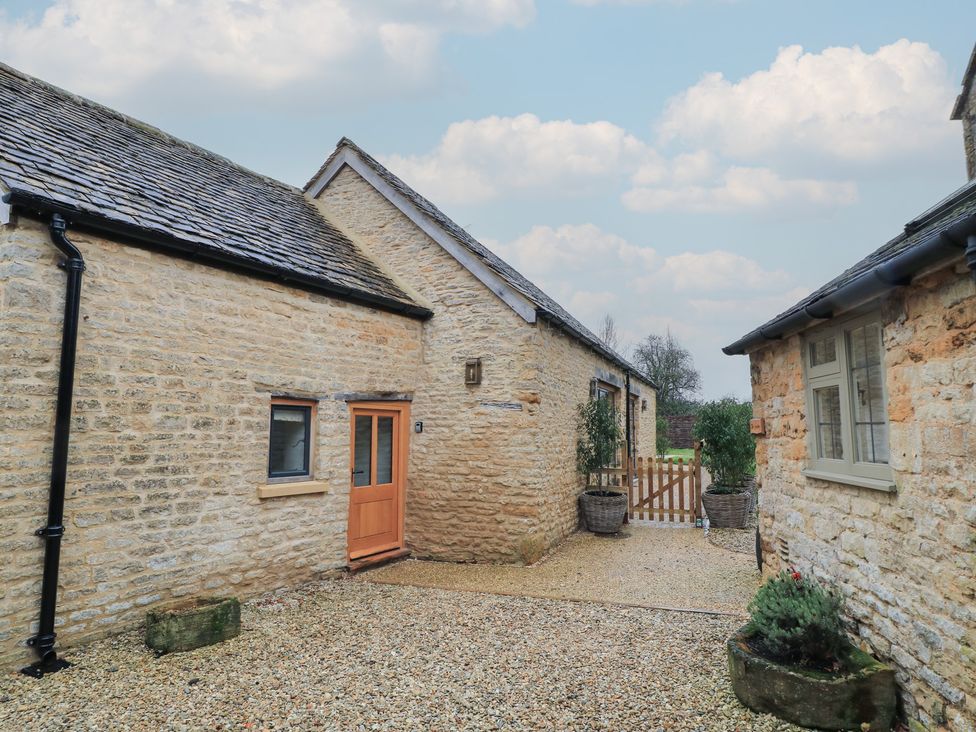 An outdoor area with stone buildings and a gravel path at The Forge in Broadwell near Stow-On-The-Wold