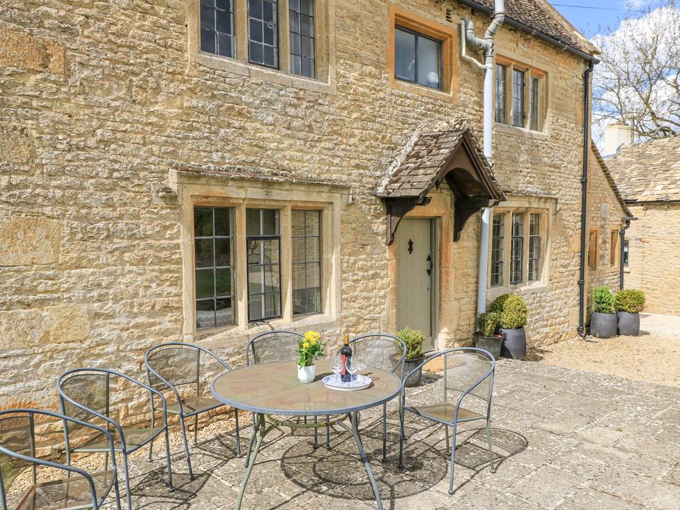 An outdoor seating area with a table and chairs at The Smithy in Stow on the wold