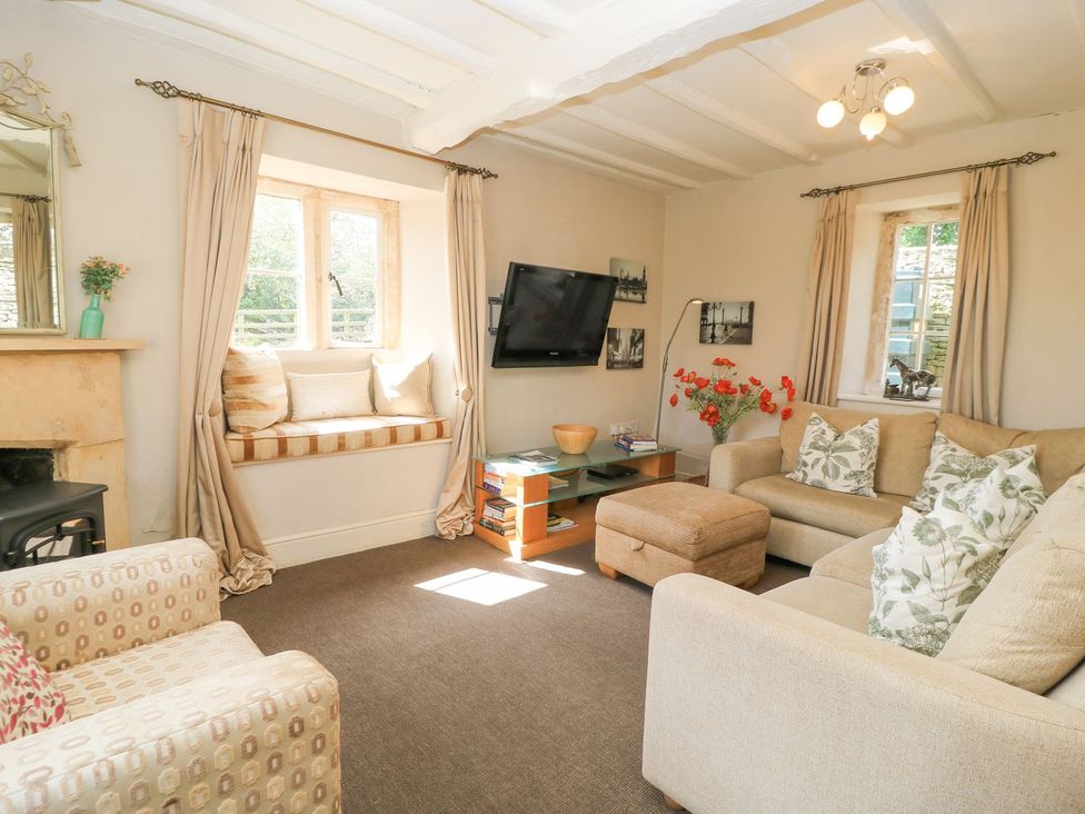 A living room with a sofa and television at The Smithy in Stow on the wold