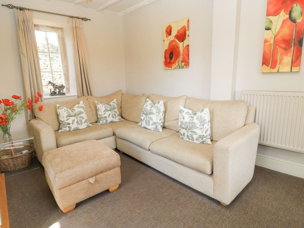 A living room with a sofa and cushions at The Smithy in Stow on the wold