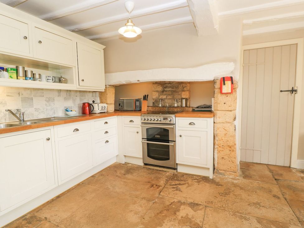 A kitchen with cabinets and an oven at The Smithy in Stow on the wold