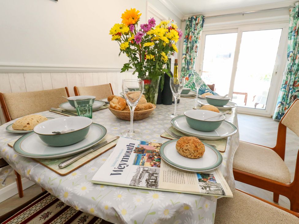 A dining table set with dishes and flowers at 46 Chafeys Avenue
