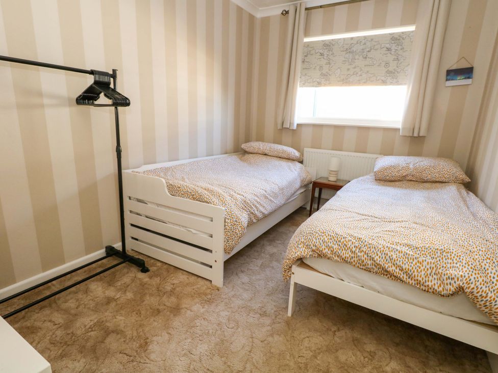 A bedroom with two beds and a small table at 46 Chafeys Avenue