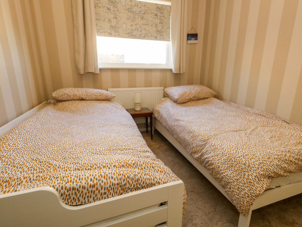 A bedroom with two single beds and a nightstand at 46 Chafeys Avenue