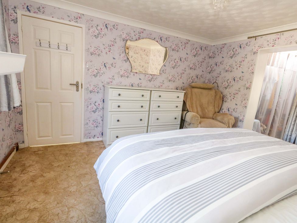 A bedroom with a chest of drawers and an armchair at 46 Chafeys Avenue