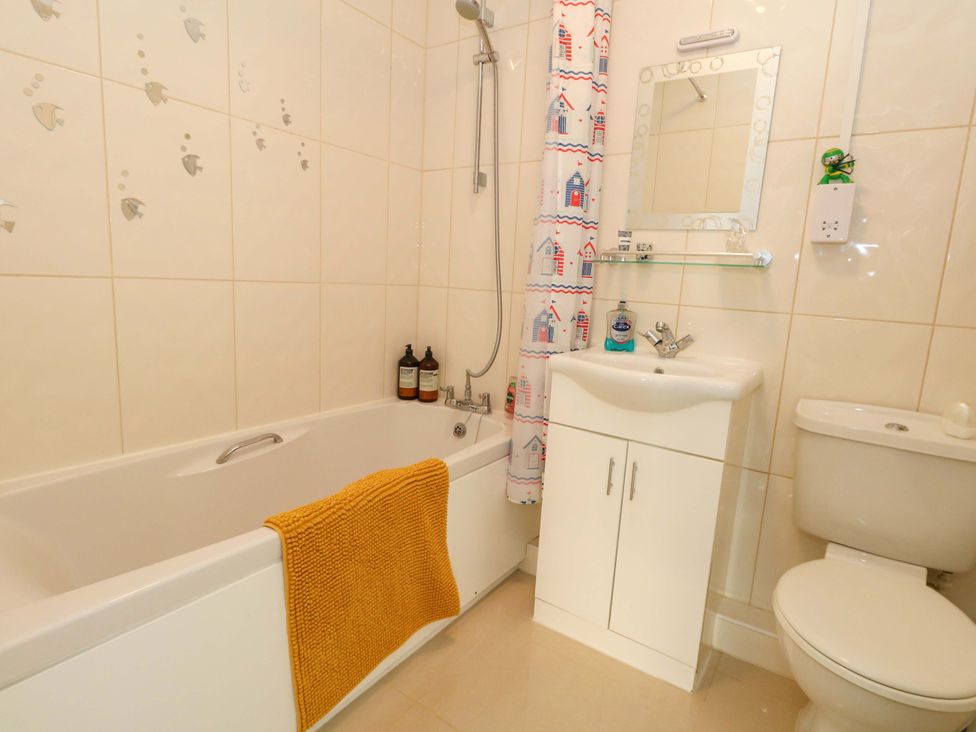 A bathroom with a bathtub, toilet, sink and mirror at 46 Chafeys Avenue